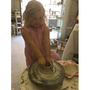 Girl thowing clay on a pottery wheel