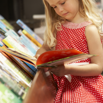 child reading a book in a bookstore